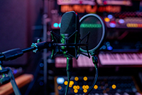 Photographie d'une console de mixage et micro de podcast.