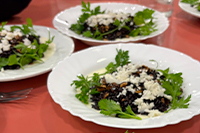 Photographie de plusieurs assiettes dressées de légumes, sur une nappe rouge.